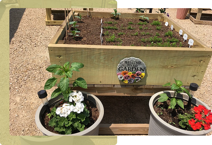 A wooden box with plants in it next to two flower pots.